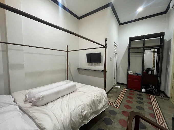 [Gambar teras luar guesthouse dengan tanaman hijau]